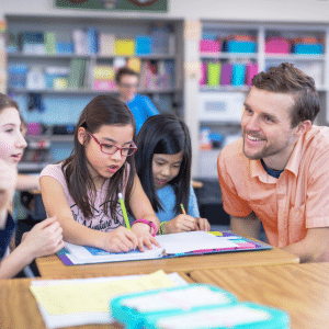 Male teacher in library with students