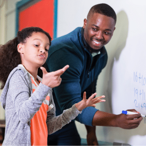 Male teacher at whiteboard with student