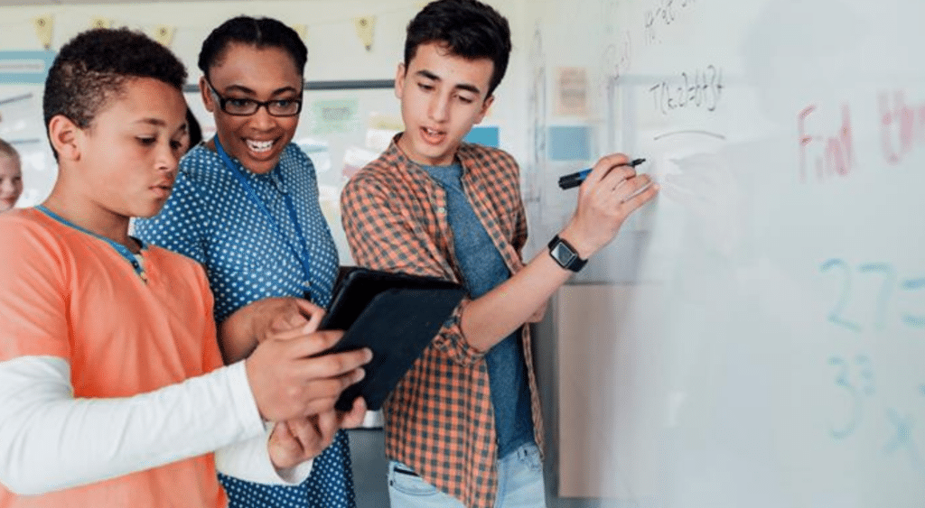 A teacher with students in front of a blackboard.