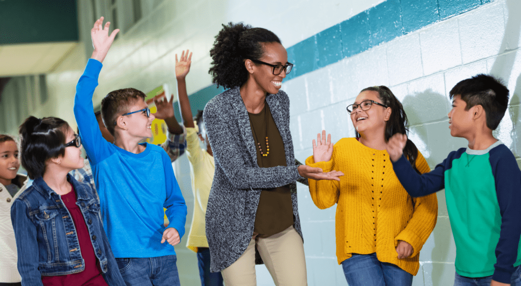 teacher talking to students in hallway