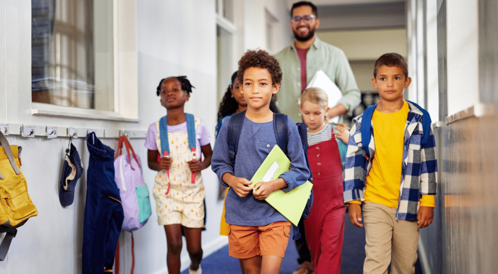 substitute teacher in building hallway with students