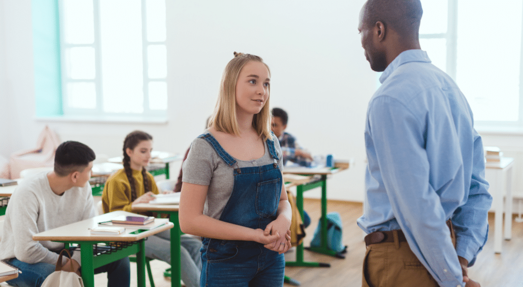 Teacher and student having a discussion at the front of the classroom