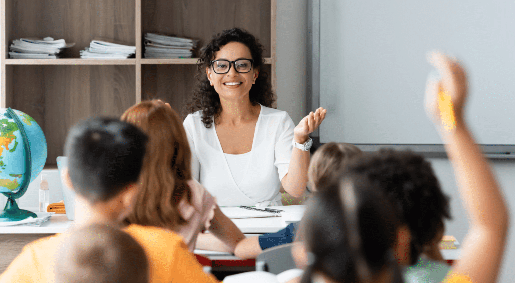 Teacher answering questions from the front of the classroom.