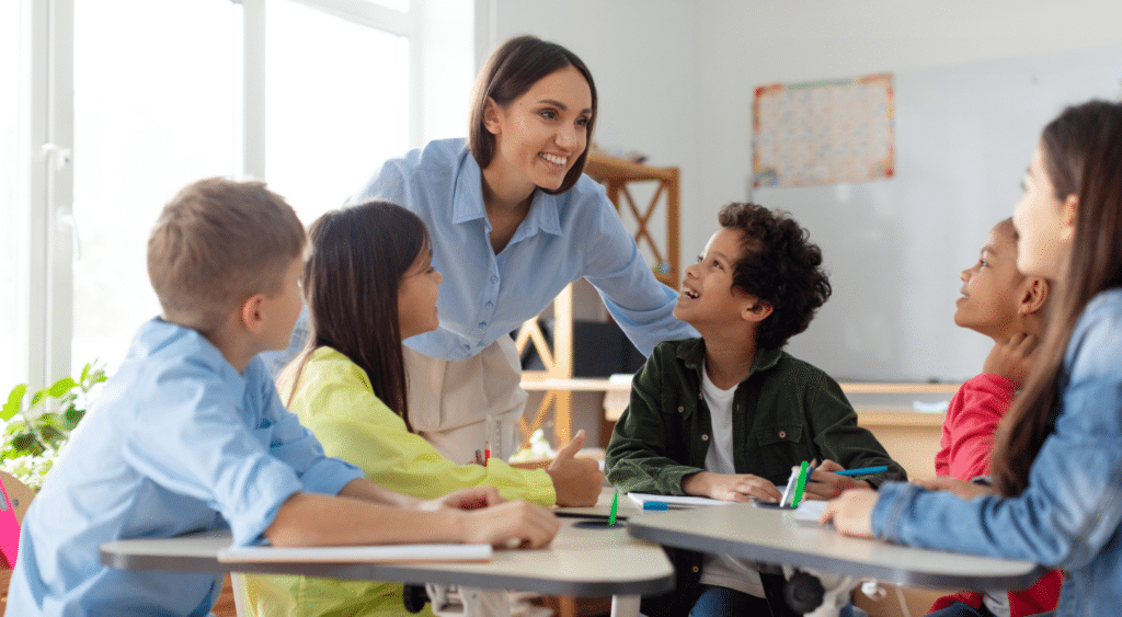 Teacher helping a small group of students at their desks.